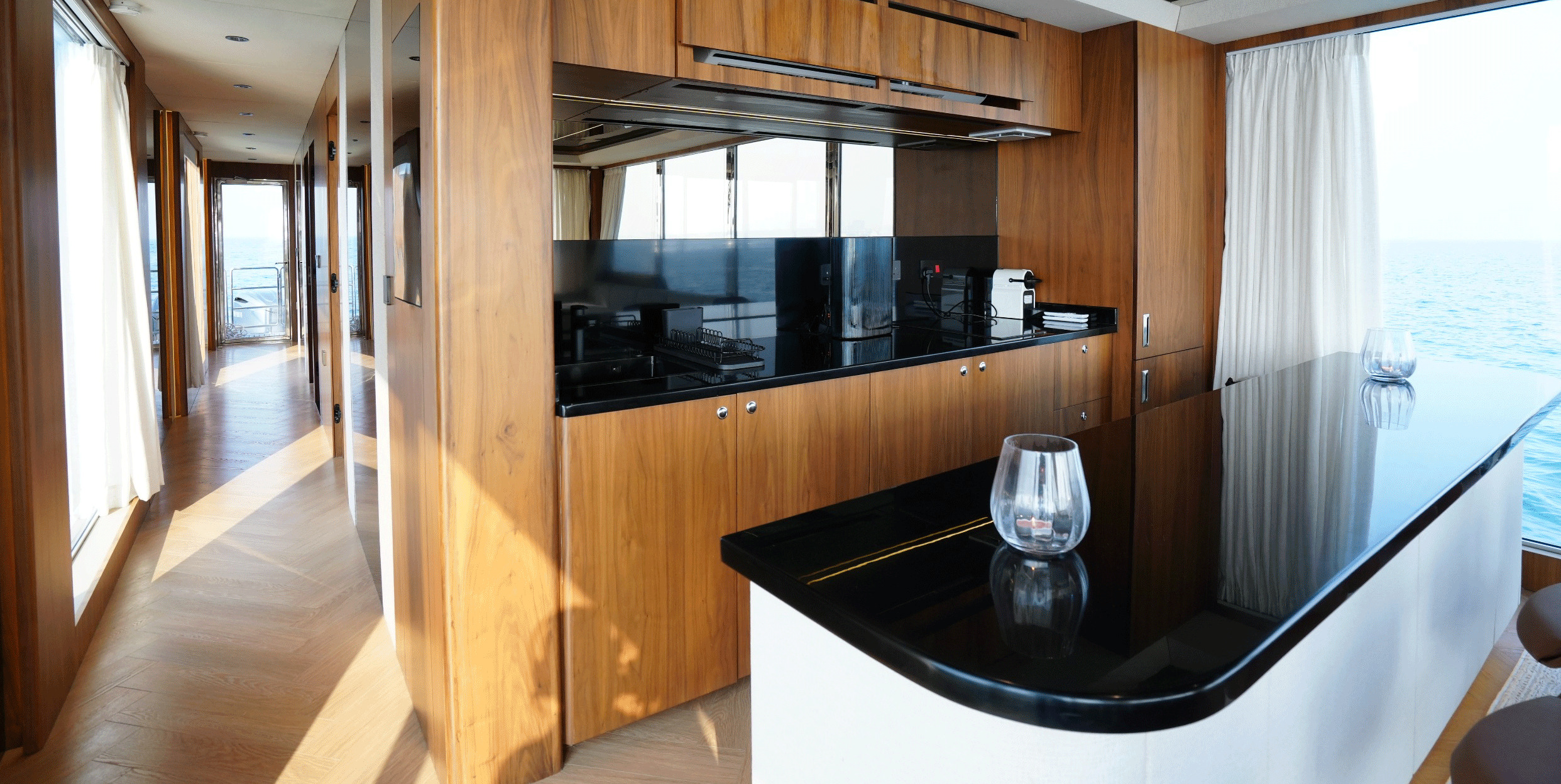 RISE 70 galley with timber joinery, black countertops and sea views